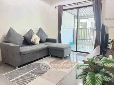 Modern living room with stylish gray sofa and balcony view