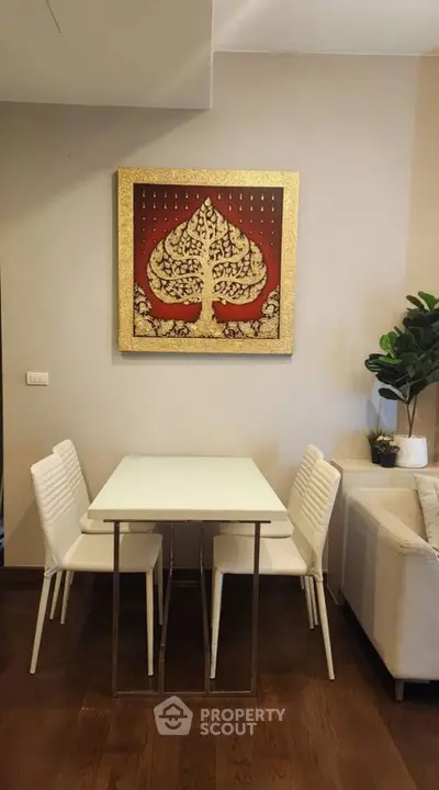 Chic dining area with modern white chairs and elegant wall art in cozy living space.