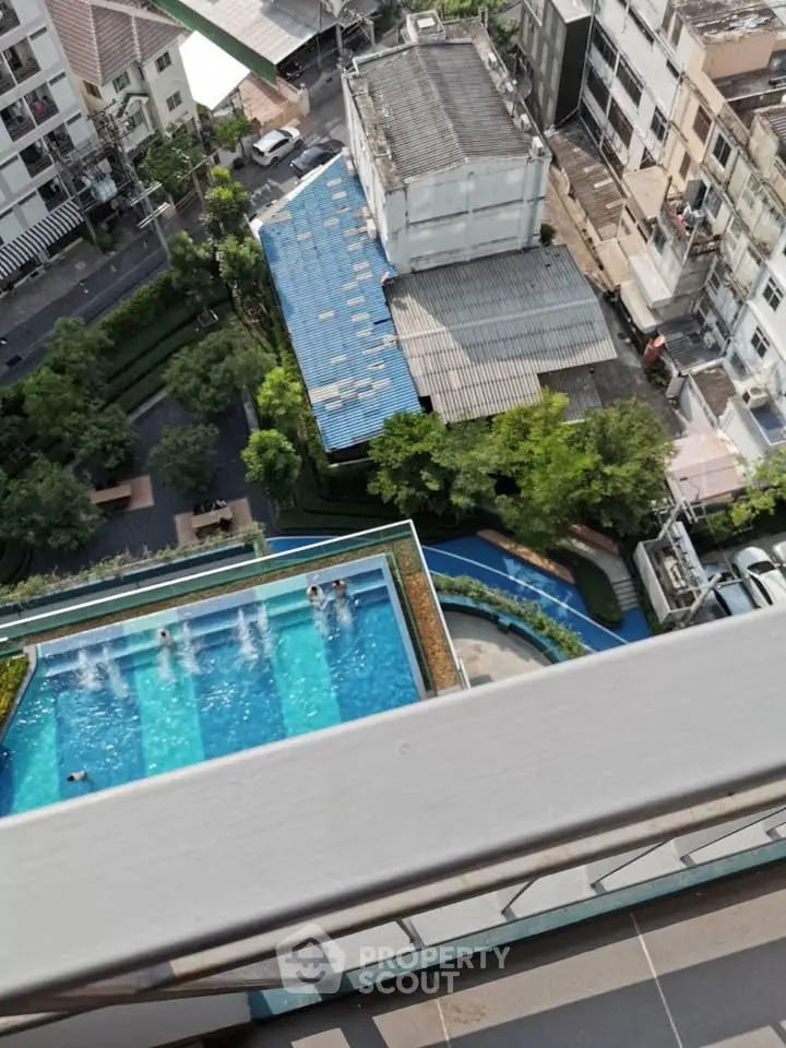 Stunning aerial view of a modern building with rooftop pool and lush greenery, perfect for urban living.