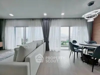 Spacious modern living room with large windows and elegant dining area