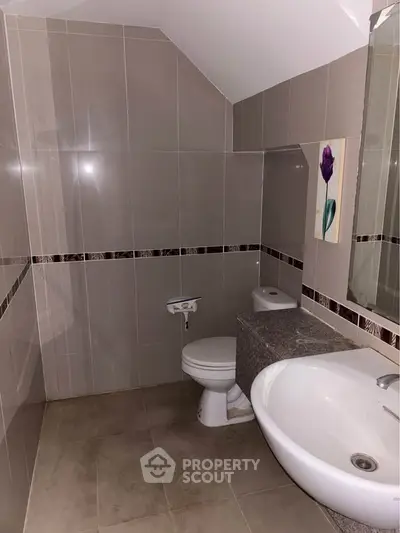 Modern bathroom with sleek tile design and elegant fixtures.
