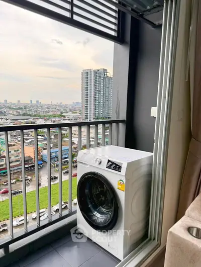 High-rise balcony with washing machine and panoramic city view.