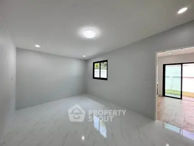 Spacious unfurnished room with modern lighting and large window, perfect for customization.