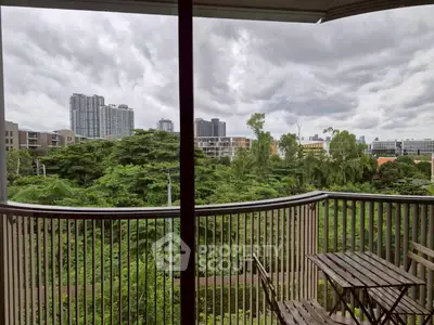 Stunning balcony view overlooking lush greenery and city skyline, perfect for relaxation.