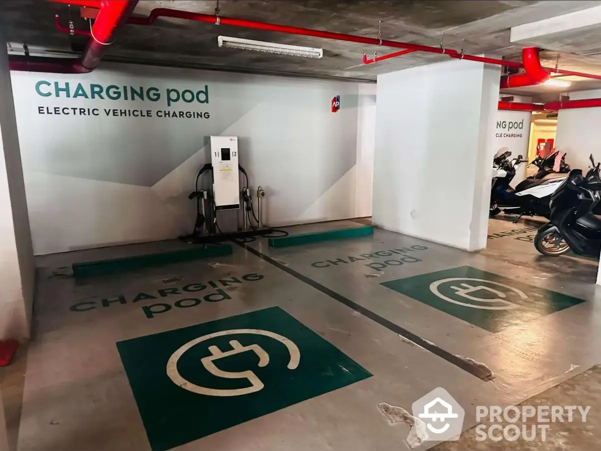 Modern parking area with electric vehicle charging stations and scooter parking.