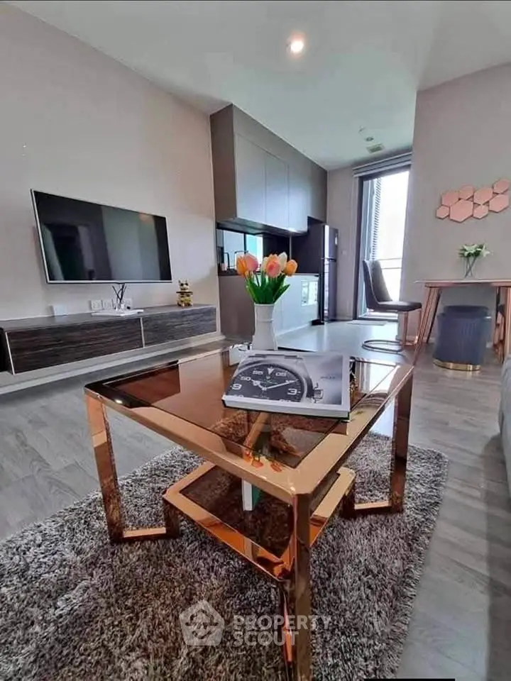 Modern living room with sleek furniture and stylish decor, featuring a wall-mounted TV and elegant coffee table.