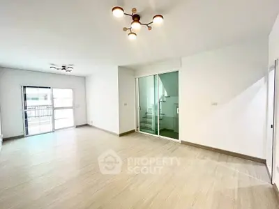 Spacious modern living room with large windows and stylish lighting, perfect for family gatherings.