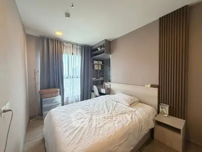 Cozy bedroom with modern decor and large window offering natural light