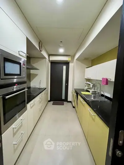 Modern kitchen with sleek cabinets and built-in appliances in a compact layout