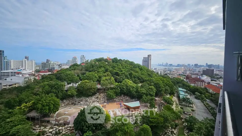 Stunning cityscape view from a high-rise balcony overlooking lush greenery and urban skyline.