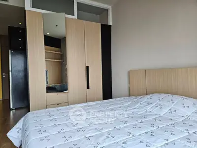Modern bedroom with stylish wooden wardrobe and cozy bed in a contemporary apartment.