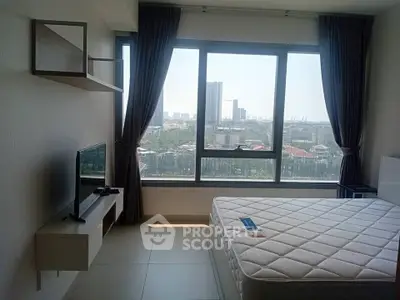 Bright bedroom with large window offering stunning city view, modern furnishings, and ample natural light.