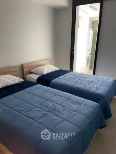 Cozy bedroom with twin beds and in-unit laundry facilities.