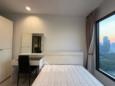 Modern bedroom with city view, featuring a sleek white bed and stylish vanity desk.
