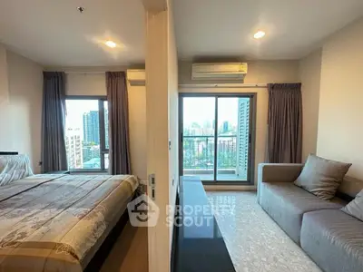 Modern apartment with bedroom and living room, featuring large windows and city views.
