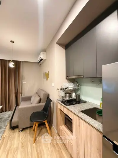 Modern open-layout kitchen and living room with sleek design and cozy ambiance.