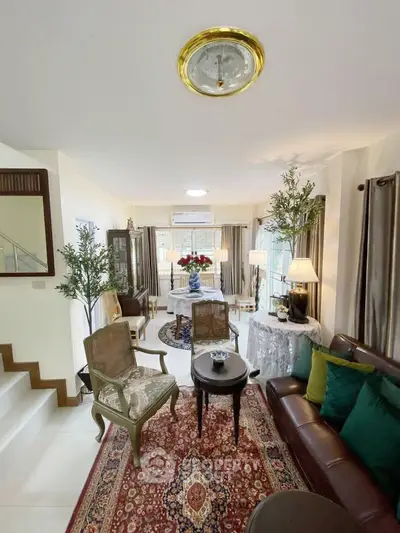 Charming living room with elegant decor and natural light, featuring cozy seating and stylish furnishings.