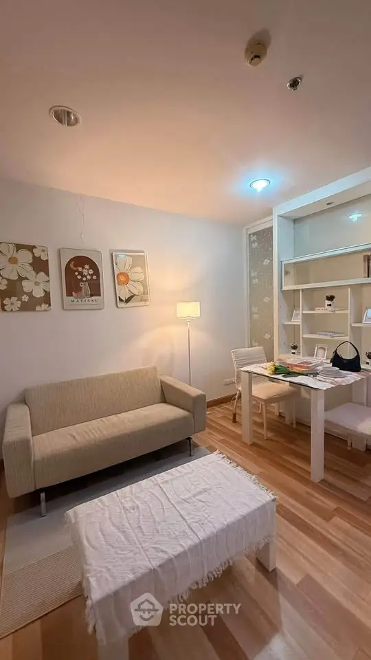 Cozy living room with modern decor and wooden flooring, featuring a comfortable sofa and stylish shelving.