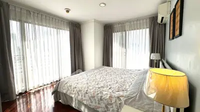 Bright and airy bedroom with large windows and elegant decor in a modern apartment.