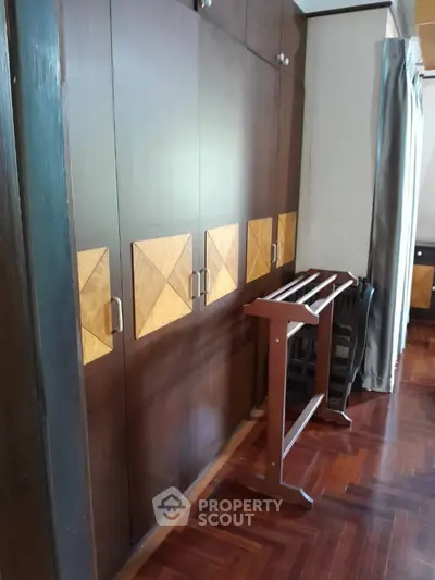 Spacious bedroom with elegant wooden wardrobe and parquet flooring
