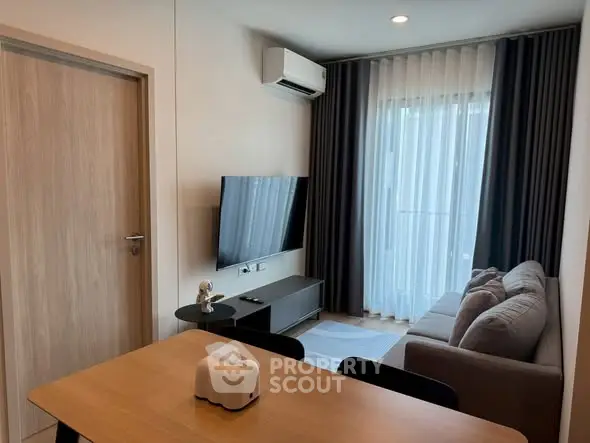 Modern living room with sleek furniture and large window, perfect for cozy urban living.