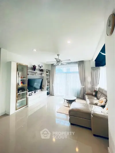 Spacious modern living room with sleek furniture and large windows for natural light.