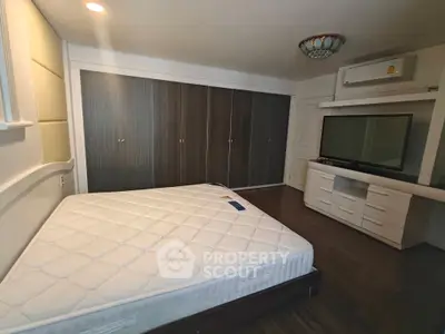 Spacious bedroom with built-in wardrobe and modern entertainment unit