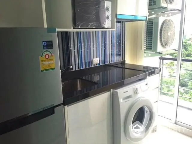 Modern kitchen with washing machine and balcony view