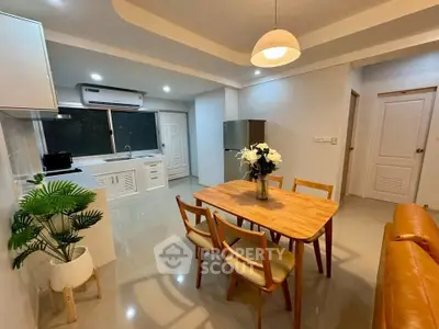 Modern open-layout kitchen and dining area with stylish furniture and ambient lighting.