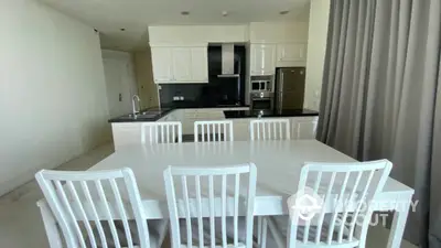 Spacious kitchen with modern white cabinetry and dining area