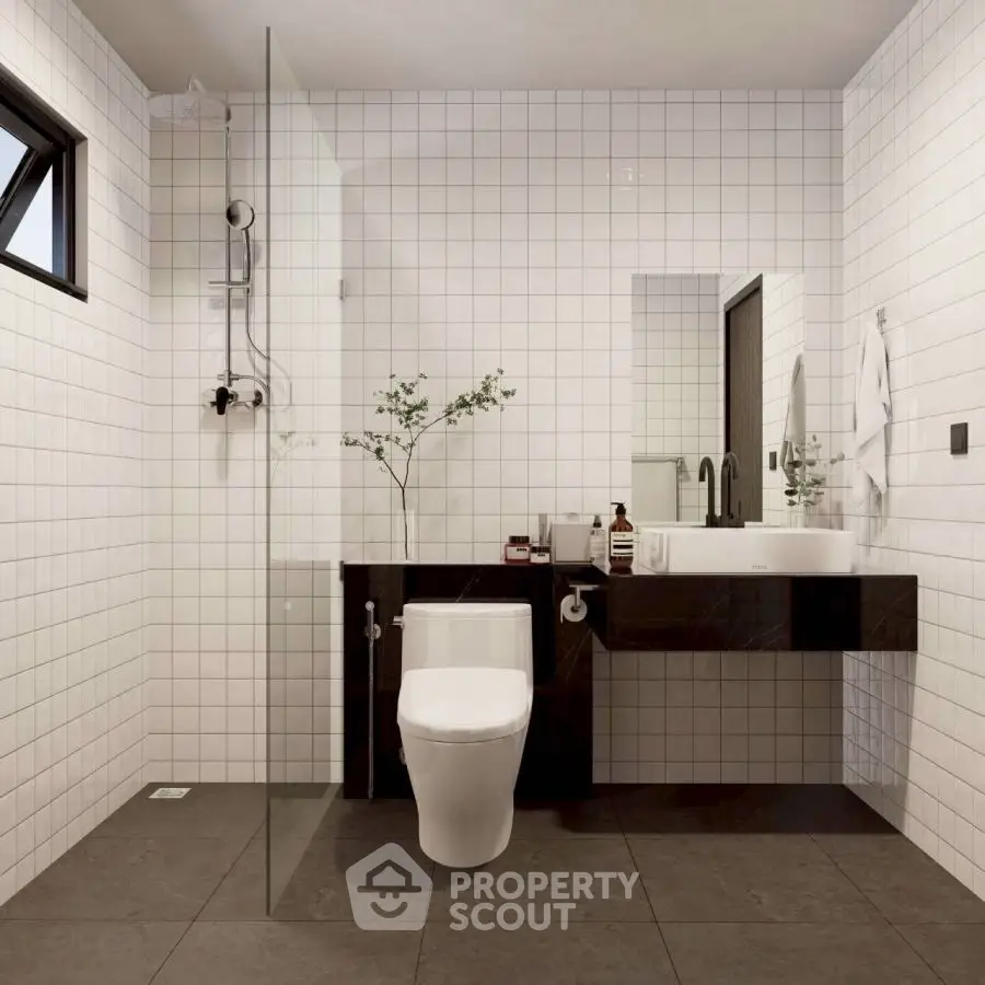 Modern bathroom with sleek fixtures and minimalist design, featuring a glass shower and stylish vanity.