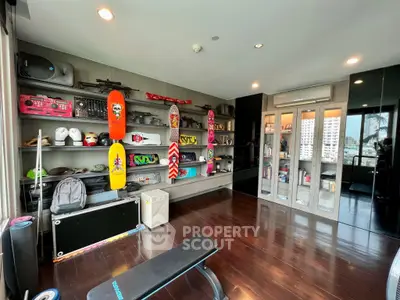 Spacious modern living area with sleek wooden flooring and an eclectic mix of vibrant skateboards and contemporary shelving units.