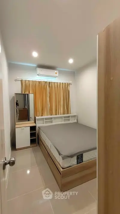 Cozy bedroom with modern furnishings and air conditioning, perfect for comfort and relaxation.