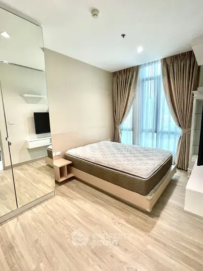 Spacious modern bedroom with large window and elegant curtains