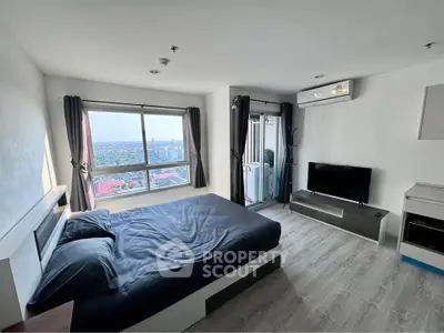 Modern bedroom with city view, featuring sleek furniture and large windows for natural light.