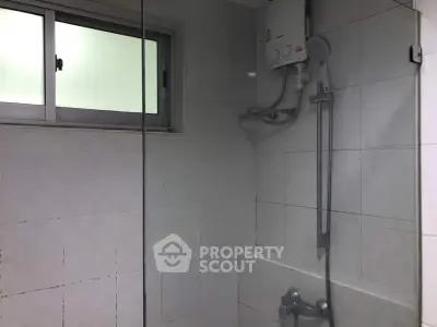 Modern bathroom with shower and frosted window, ideal for privacy and relaxation.