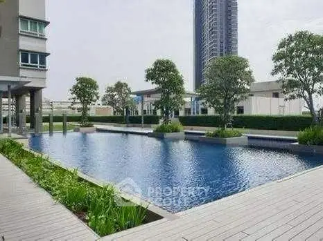Luxurious modern apartment complex with serene pool and lush greenery.