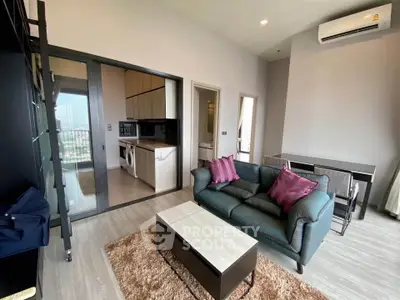 Modern living room with open kitchen and city view, featuring stylish furniture and air conditioning.