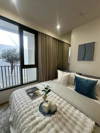 Cozy bedroom with modern decor and large window overlooking a serene balcony.