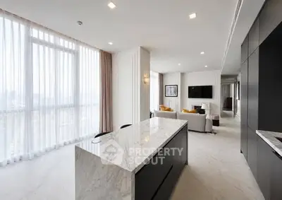 Luxurious open-plan living room with modern kitchen and stunning city view.