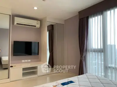 Modern bedroom with mirrored closet, air conditioning, and large window with city view.