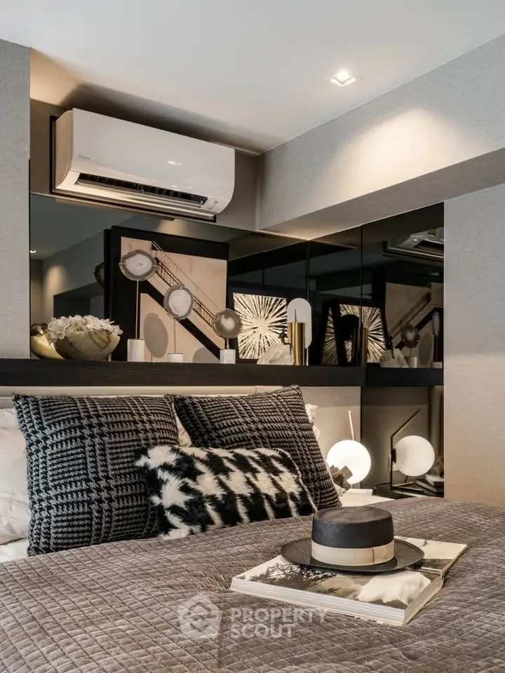 Luxurious bedroom with modern decor and air conditioning, featuring stylish artwork and cozy bedding.