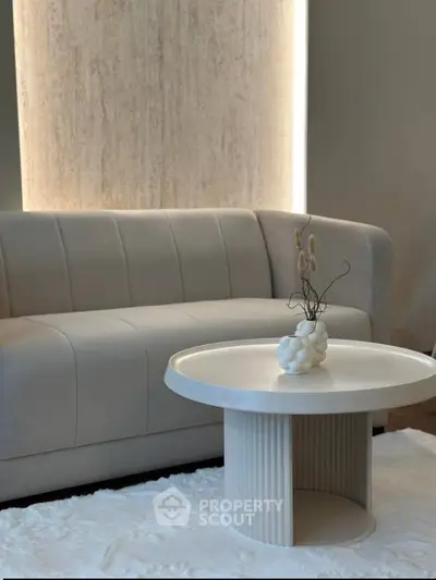 Elegant modern living room with stylish sofa and chic round coffee table on plush rug.
