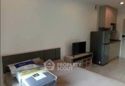 Modern studio apartment with compact kitchen and cozy sleeping area, ideal for urban living.