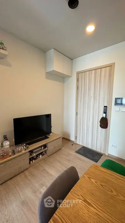 Modern living room with wooden flooring and sleek TV setup, perfect for cozy evenings.