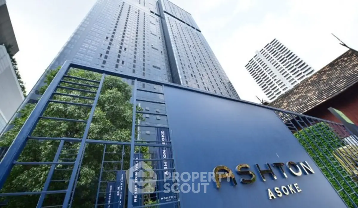 Modern high-rise building with sleek design and prominent entrance signage.
