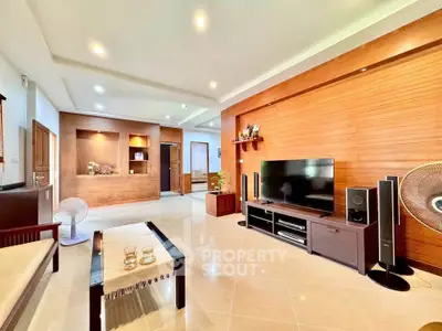 Spacious modern living room with wooden accents and sleek entertainment setup.