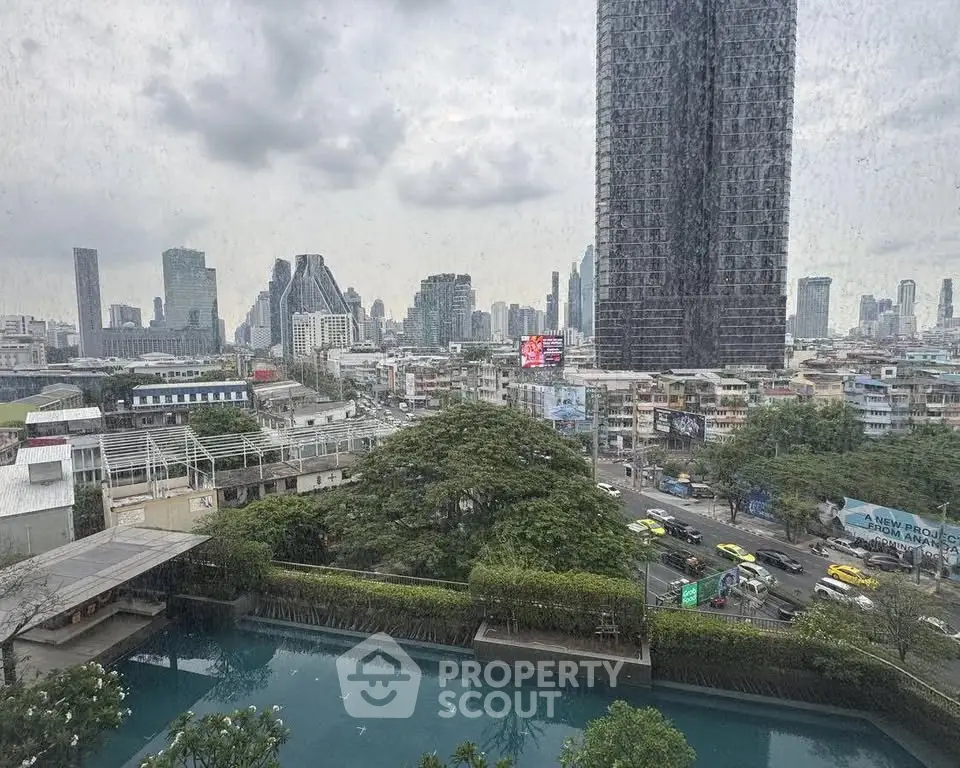 Stunning cityscape view from high-rise building with pool and lush greenery.