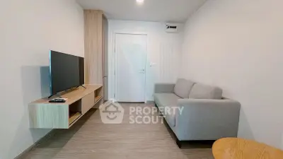 Modern living room with sleek TV setup and cozy gray sofa in a minimalist design.