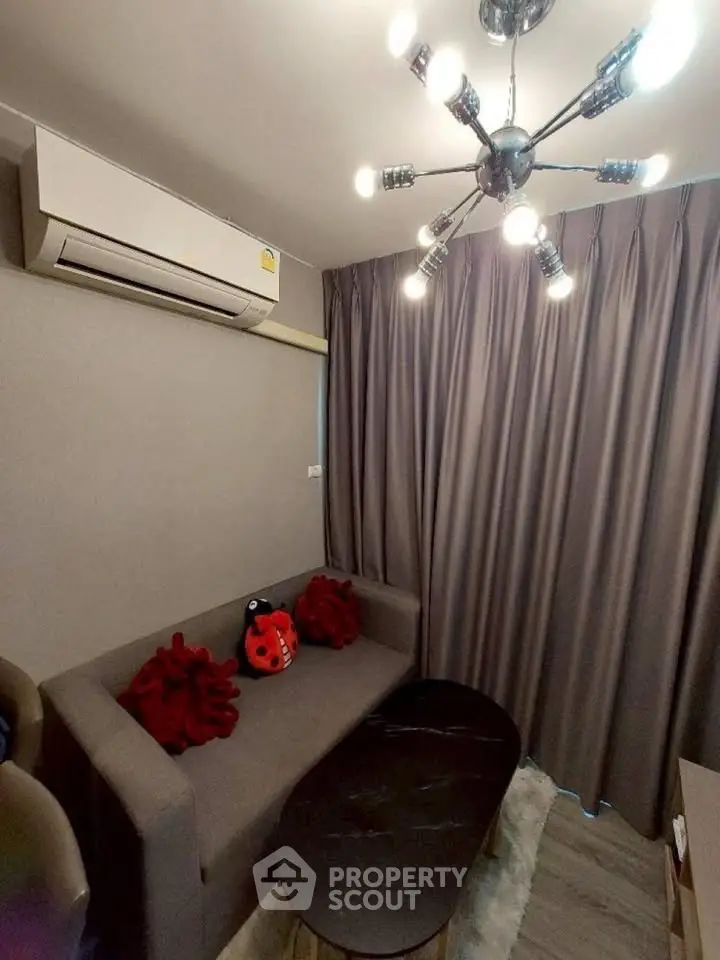 Modern living room with stylish lighting and cozy sofa in a compact space.